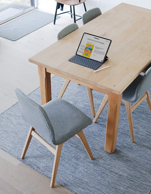 Desk with computer on it and comfortable chair that is standing nearby
